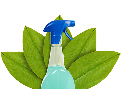 green leaf behind cleaning spray bottle